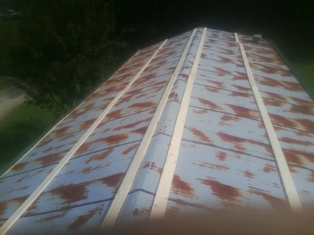 Rusted metal roof panels with new wood purlins before replacement — Storm Damage Roof Repair in Mount Summit by Roofing Brothers